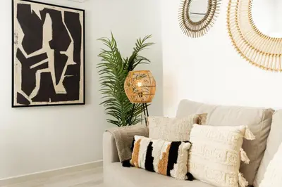 a living room with a couch and a plant at Apartamento Mucha Vida Little Apartments in Cádiz