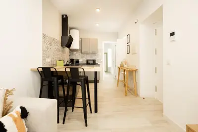 a kitchen and living room with a table and chairs at Apartamento Mucha Vida Little Apartments in Cádiz