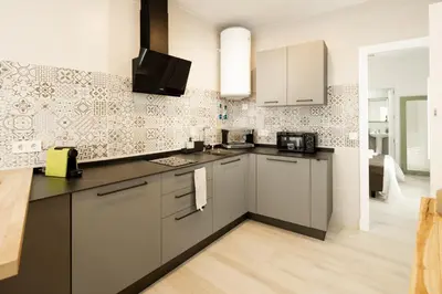 a kitchen with stainless steel appliances and tiles at Apartamento Mucha Vida Little Apartments in Cádiz