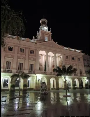 a large building with a clock tower at night at Apartamento Mucha Vida Little Apartments in Cádiz