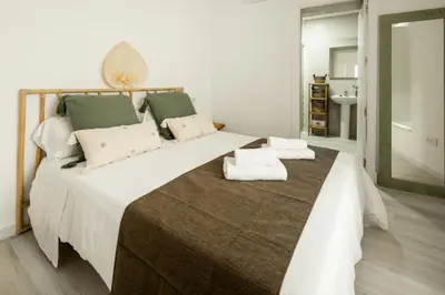a bedroom with a large bed with towels on it at Apartamento Mucha Vida Little Apartments in Cádiz