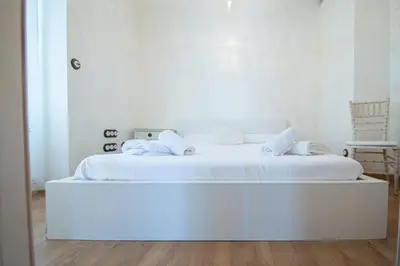 a white bedroom with a large white bed at Apartamento Sherezade y la ciudad de Cádiz in Cádiz