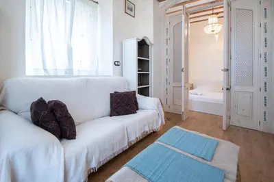 a living room with a white couch and a window at Apartamento Sherezade y la ciudad de Cádiz in Cádiz