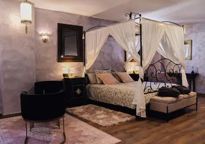 a bedroom with a canopy bed and a chair at Riad Medina Mudéjar Cádiz in Chiclana de la Frontera
