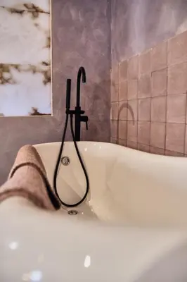 a bath tub with a towel and a faucet at Riad Medina Mudéjar Cádiz in Chiclana de la Frontera