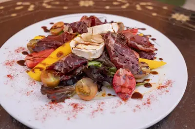 a plate of food with meat and vegetables on a table at Riad Medina Mudéjar Cádiz in Chiclana de la Frontera