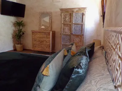 a room with pillows on a bed with a television at Riad Medina Mudéjar Cádiz in Chiclana de la Frontera