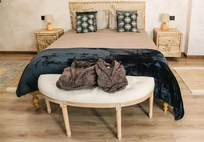 a bedroom with a bed with a white table with clothes on it at Riad Medina Mudéjar Cádiz in Chiclana de la Frontera