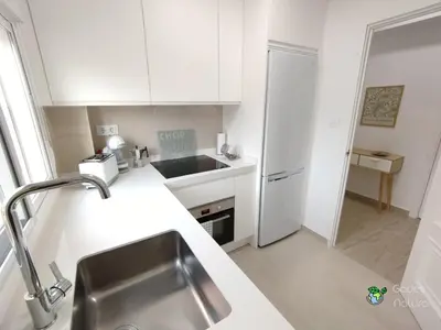 a white kitchen with a sink and a refrigerator at Gades Natura Victoria Beach in Cádiz