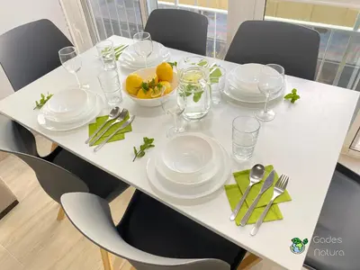 a white table with plates and dishes on it at Gades Natura Victoria Beach in Cádiz