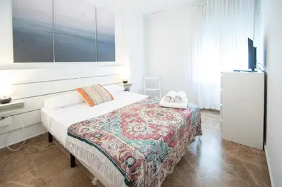 a bedroom with a bed and a tv on the wall at Apartamento El Anteojo de Cádiz in Cádiz