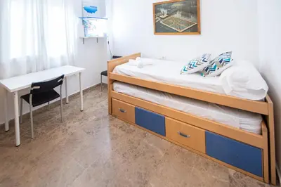 a bedroom with a bed and a desk and a table at Apartamento El Anteojo de Cádiz in Cádiz