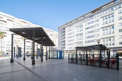 a bus stop in a city with a building at Apartamento El Anteojo de Cádiz in Cádiz
