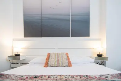 a bedroom with a bed with a painting above it at Apartamento El Anteojo de Cádiz in Cádiz