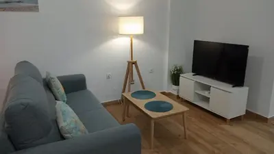 a living room with a blue couch and a tv at Apartamento Mar II in San Fernando