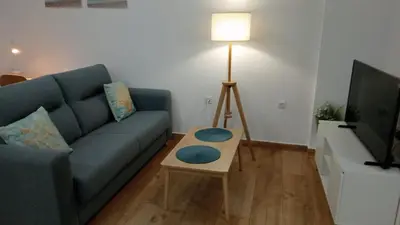 a living room with a blue couch and a table at Apartamento Mar II in San Fernando