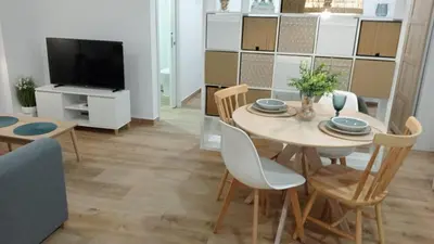 a dining room with a table and chairs and a tv at Apartamento Mar II in San Fernando