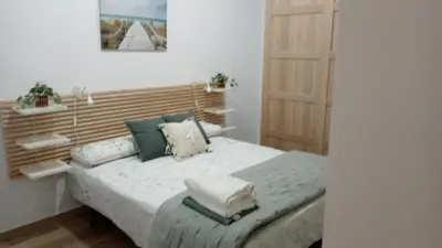 a bedroom with a bed with a wooden headboard at Apartamento Mar II in San Fernando