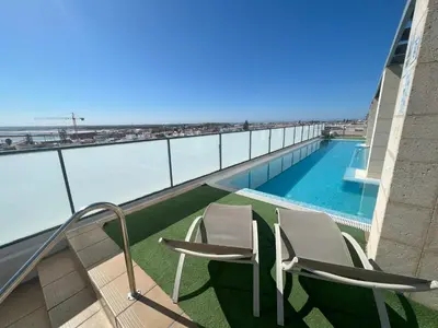 a balcony with two chairs and a swimming pool at GATU PREMIUM Marismas, terraza, parking, piscina común y aire acc , 