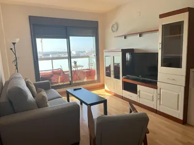 a living room with a couch and a flat screen tv at GATU PREMIUM Marismas, terraza, parking, piscina común y aire acc , 