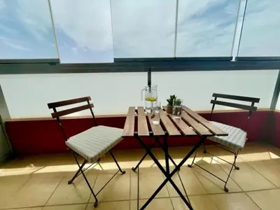 two chairs and a wooden table in a room at GATU PREMIUM Marismas, terraza, parking, piscina común y aire acc , 