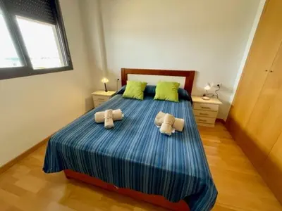 a bedroom with a large bed with two pillows at GATU PREMIUM Marismas, terraza, parking, piscina común y aire acc , 