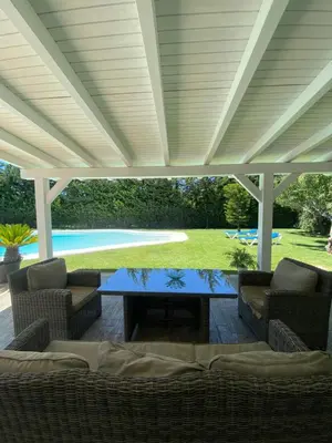 a patio with a table and chairs under a pergola at Chalet Brisas del Mar in Chiclana de la Frontera