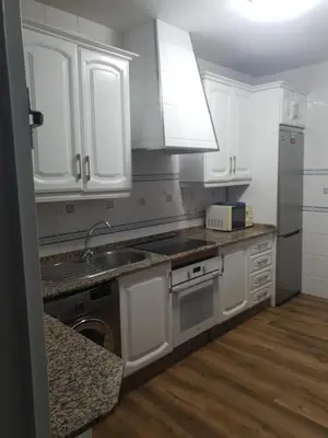 a kitchen with white cabinets and a sink at Chalet Brisas del Mar in Chiclana de la Frontera