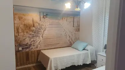 a bedroom with a painting of a beach and a bed at Chalet Brisas del Mar in Chiclana de la Frontera