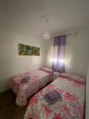 a bedroom with two beds and a painting on the wall at Chalet Brisas del Mar in Chiclana de la Frontera