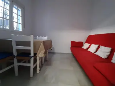a living room with a red couch and a table at Villa Puerto Santa María in El Puerto de Santa María