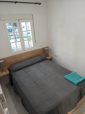 a bedroom with a large bed and two windows at Villa Puerto Santa María in El Puerto de Santa María