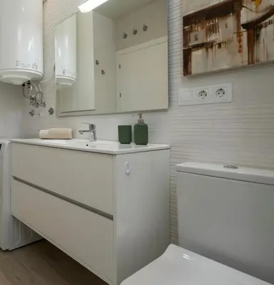 a white bathroom with a sink and a toilet at Alma Playa la Caleta Grupo AC Gestion in Cádiz