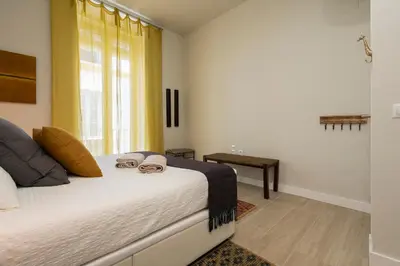 a bedroom with a bed with two glasses on it at Alma Playa la Caleta Grupo AC Gestion in Cádiz