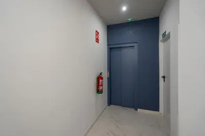 a hallway with a blue door and a fire hydrant at Alma Playa la Caleta Grupo AC Gestion in Cádiz