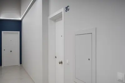 a row of white doors in a hallway at Alma Playa la Caleta Grupo AC Gestion in Cádiz