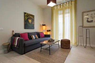 a living room with a couch and a table at Alma Playa la Caleta Grupo AC Gestion in Cádiz