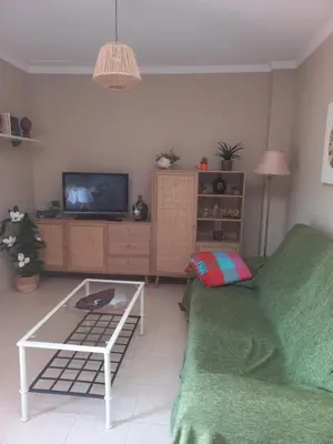a living room with a white couch and a tv at EL ATICO DE MARIA con garaje, piscina y terraza in El Puerto de Santa María