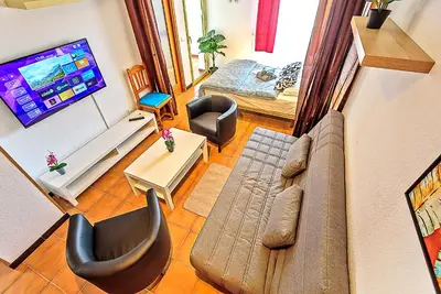 a living room with a couch and a flat screen tv at Ocean View Beach Apartment with Pool & Balconies in El Puerto de Santa María