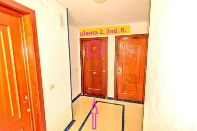 a room with a door with a pink sign on it at Ocean View Beach Apartment with Pool & Balconies in El Puerto de Santa María