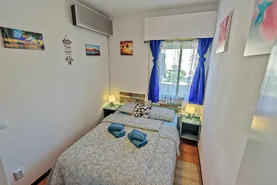 a bedroom with two beds and a window at Ocean View Beach Apartment with Pool & Balconies in El Puerto de Santa María