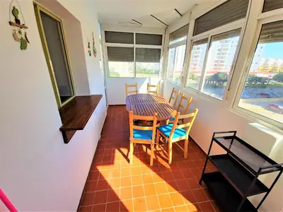 a dining room with a table and chairs and windows at Ocean View Beach Apartment with Pool & Balconies in El Puerto de Santa María