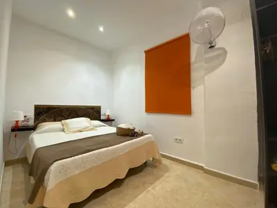 a bedroom with a bed and a fan on the wall at Alojamiento Cazón, Jerez Centro in Jerez de la Frontera