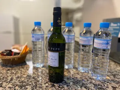 a bottle of wine sitting on a counter with water bottles at Alojamiento Cazón, Jerez Centro in Jerez de la Frontera