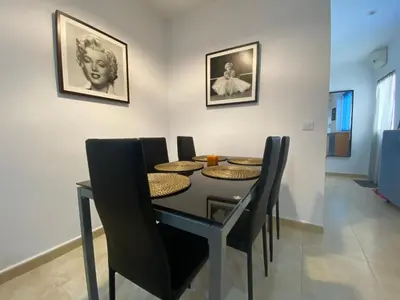 a dining room with a black table and black chairs at Alojamiento Cazón, Jerez Centro in Jerez de la Frontera