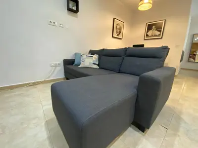 a living room with a blue couch in a room at Alojamiento Cazón, Jerez Centro in Jerez de la Frontera