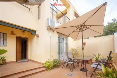 a patio with a table and chairs and an umbrella at El Anfitrión - Dúplex Doña Ana in Sanlúcar de Barrameda