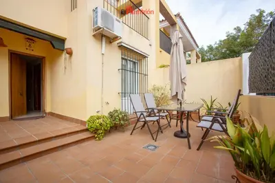 a patio with a table and chairs and an umbrella at El Anfitrión - Dúplex Doña Ana in Sanlúcar de Barrameda