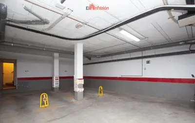 an empty parking garage with a red and white wall at El Anfitrión - Dúplex Doña Ana in Sanlúcar de Barrameda