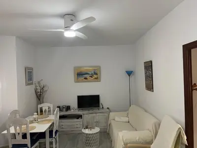 a living room with a couch and a table at ACOGEDOR APARTAMENTO EN SANLUCAR DE BARRAMEDA in Sanlúcar de Barrameda